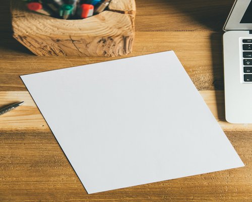 A notebook and pen on a clean wooden desk