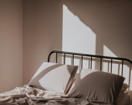 Morning light shining gently on a made bed